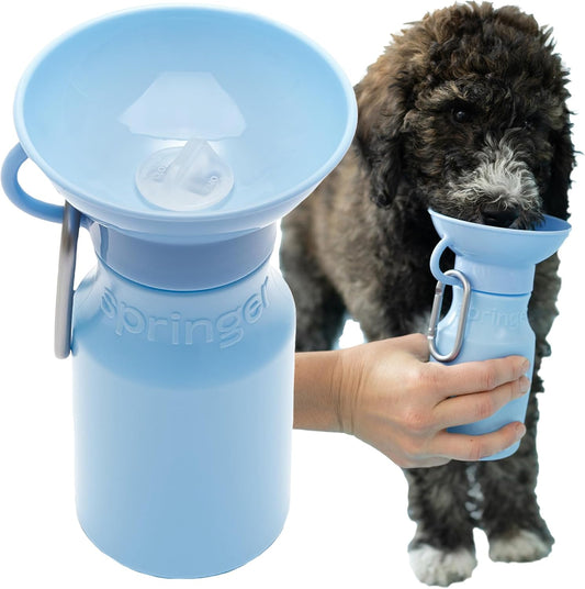 Dog drinking from portable water dispenser