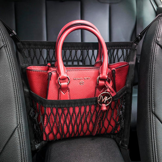 Car seat organizer with dog barrier mesh and storage pockets installed between front seats to organize essentials and keep pets safely in the back seat.